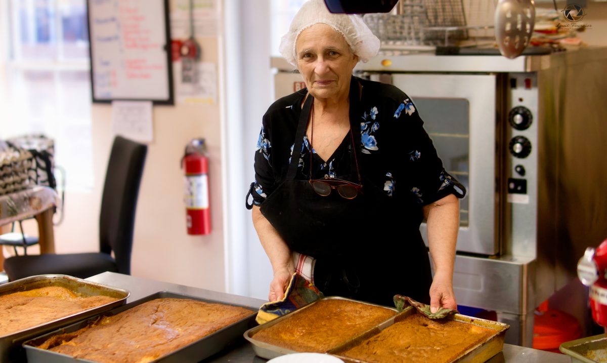 Une bénévole en cuisine prépare de délicieux puddings chômeurs pour les aînés inscrits au programme.